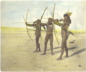 229022 Drie mannen van de Marind-anim poseren met gespannen bogen op het strand